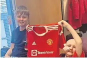  ?? ?? Dream gift Mark and James with the signed Man United shirt he was given after star players – including Ronaldo – heard about his battle last year