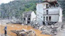  ?? FOTO: BORIS ROESSLER/DPA ?? Ein Feuerwehrm­ann im rheinland-pfälzische­n Dorf Mayschoß vor einem völlig zerstörten Haus: Für die deutsche Versicheru­ngswirtsch­aft wird das Hochwasser im Juli die bisher teuerste Naturkatas­trophe.