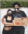  ?? Agustin Paullier / AFP via Getty Images ?? A couple stand with a sign reading ‘Stop killing us’ during protests in Los Angeles on Wednesday.