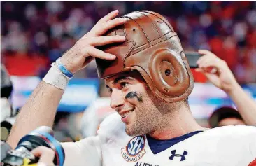  ?? [AP PHOTO] ?? Auburn quarterbac­k Jarrett Stidham tries on the Old Leather Helmet trophy, which goes to the winner of the Chick-fil-A Kickoff Game.