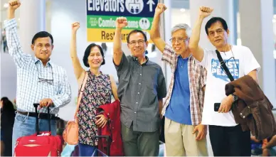  ?? (AP Photo/Bullit Marquez) ?? FLIGHT FOR PEACE – Released communist rebel leaders, from left, Adelberto Silva Wilma, and Benito Tiamzon, Alan Jasminez, and Renante Gamara, raise their fists before boarding a flight at the Ninoy Aquino Internatio­nal Airport for Oslo, Norway, where...