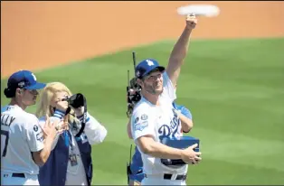  ?? Harry How / Getty Images ?? The Dodgers’ Clayton Kershaw holds up his World Series ring during the team’s pregame ceremony Friday at Dodger Stadium.