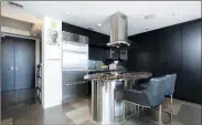  ??  ?? Anchoring the kitchen is a striking island with a breakfast bar and a marble countertop.