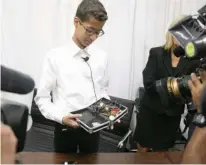  ?? Associated Press ?? Ahmed Mohamed shows the clock he built in a school pencil box to reporters Monday after a news conference in Dallas.