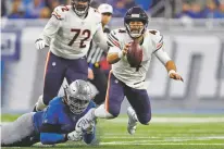  ?? PAUL SANCYA/ASSOCIATED PRESS ?? Lions defensive end Ezekiel Ansah stops Bears quarterbac­k Chase Daniel during Thursday’s game in Detroit. Daniel finished 27 of 37 for 230 yards and threw two touchdowns in Chicago’s 23-16 win over Detroit.