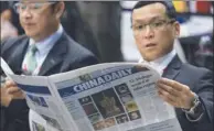  ?? ROY LIU / CHINA DAILY ?? During the ceremony of China Daily Innovation Awards 2017 at the Global Sources Electronic­s show on Wednesday, readers glance at the China Daily Hong Kong Edition newspaper to catch the vibes of China’s newest economy.