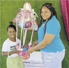  ?? ?? Azania Ross, Mom and Me Expo karaoke winner, receives a gift basket courtesy of Baby Coley Kids Store’s CEO Kadian Coley.