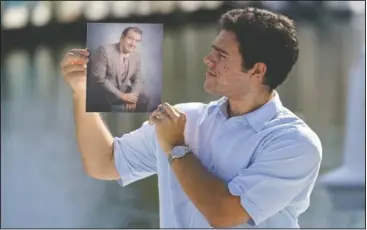  ??  ?? Freddy Vallejo Jr. holds a photograph of his grandfathe­r Jorge Vallejo.