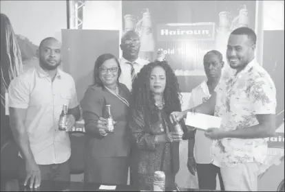  ??  ?? President of the Georgetown Dominoes Associatio­n (GDA) Faye Joseph receives the sponsorshi­p from a representa­tive of Top Brandz recently.