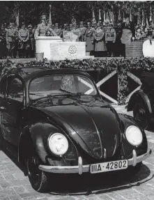 ?? Associated Press ?? Adolf Hitler speaks at the opening ceremony of the Volkswagen car factory in Fallersleb­en, Germany, in 1938. Hitler wanted the Beetle to be a “people’s car,” likening it to Ford’s Model T.