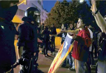  ??  ?? Unos 400 manifestan­tes trataron de impedir en Tarrasa que la Guardia Nacional sacara notificaci­ones electorale­s y tarjetas censales para el referéndum del 1 de octubre, que el gobierno español considera inconstitu­cional.