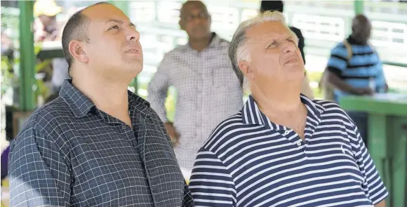  ?? (Photo: Observer file) ?? Jason Dacosta (left) watching the replay of a race with his father Wayne.