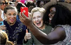  ?? JUSTIN SULLIVAN/GETTY ?? Democrat Hillary Clinton shares smiles Sunday with early voters in North Carolina.