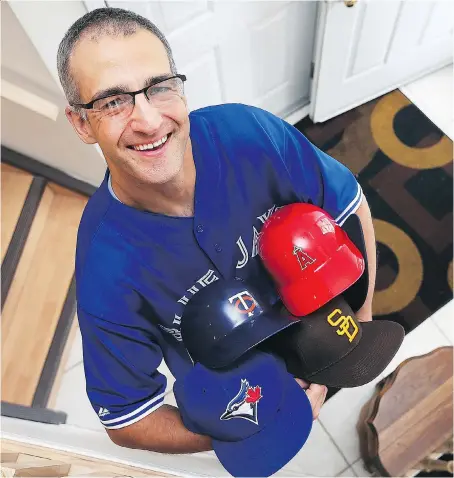  ?? DAN JANISSE ?? Jim Beland, who recently completed his goal of attending a baseball game in all 30 Major League Baseball parks, shows off some of his game-related souvenirs at his Windsor home. “It’s kind of neat and it’s been a lot of fun,” the math teacher said of...