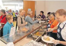  ?? FOTO: HELMUT VOITH ?? Auch die Bürgermeis­ter packen mit an bei der Vesperkirc­he – hier Achim Krafft aus Langenarge­n beim Essenschöp­fen.