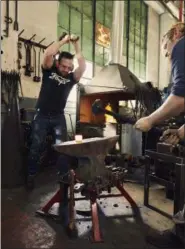  ?? SULLY SULLIVAN — ROBERT THOMAS VIA AP ?? Robert Thomas, left, works with Matt Garton to make a custom blacksmith tool at the RTID studio in North Charleston, S.C.