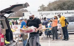  ?? MARIE D. DE JESUS/HOUSTON CHRONICLE ?? Enrique Albi of the Houston Food Bank loads food into a vehicle Sunday in the aftermath of frigid temperatur­es that hit Texas last week. Hospitals in the state and throughout the South are struggling with water shortages.