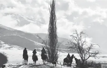  ?? — AFP photos by Vyacheslav Oseledko ?? Riders on horses travel along a street in the village of Syn-Tash, some 60 kms from Bishkek.