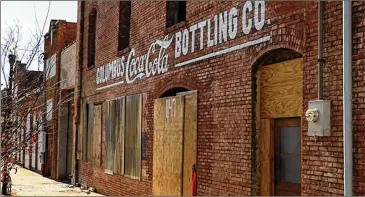  ?? MIKE HASKEY/(COLUMBUS) LEDGER-ENQUIRER ?? The Columbus Coca-Cola Bottling Co. property was one of the earliest Coca-Cola bottling franchises, and it was owned by Columbus Roberts Sr. In 1905, Roberts moved into this large brick building on Sixth Avenue. This building now serves as an iconic, nostalgic piece of American history.