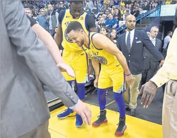  ?? FILE PHOTO ?? Golden State Warriors’ Stephen Curry limps back to the court after injuring his right ankle as teammate Draymond Green checks on his condition during the first quarter of their NBA game at Oracle Arena in Oakland on March 8.