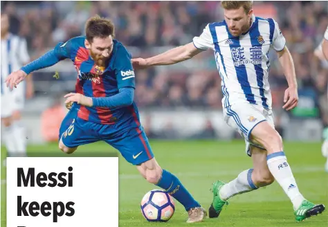  ?? — AFP ?? Barcelona’s Lionel Messi (left) vies with Real Sociedad’s Asier Illarramen­di (right) during the Spanish league match at the Camp Nou Stadium in Barcelona on Saturday.