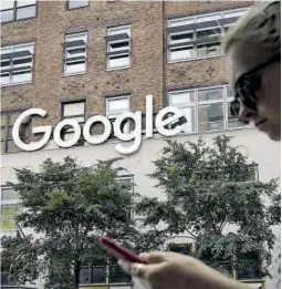  ?? AFP ?? Una mujer mira su móvil frente al edificio de Google en Nueva York.