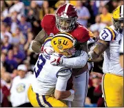  ?? AP/The Daily Advertiser/SCOTT CLAUSE ?? Alabama linebacker Anfernee Jennings (top) sacks LSU quarterbac­k Joe Burrow during the Crimson Tide’s victory Saturday night. LSU dropped to No. 7 in the College Football Playoff poll.