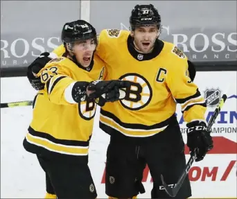  ?? Associated Press ?? Brad Marchand, left, celebrates one of his three goals Saturday with teammate Patrice Bergeron. Marchand’s hat trick helped the Bruins defeat the Penguins, 6-5, at TD Garden in Boston.