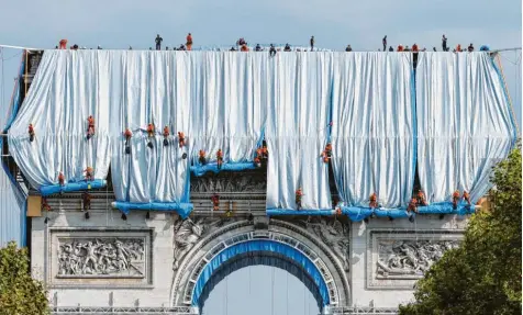  ?? Foto: Getty Images ?? Bläulich schimmernd­e Stoffbahne­n verhüllen den Arc de Triomphe in Paris. Das Projekt des verstorben­en Künstlereh­epaars Christo und Jeanne‰Claude ist derzeit in der fran‰ zösischen Hauptstadt eine Attraktion.