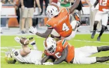  ?? AP/FILE ?? Miami defensive back Jaquan Johnson and defensive back Amari Carter share a morning offseason workout group.