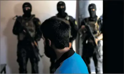  ?? The Associated Press ?? RAQQA: In this file picture taken on Friday, July 21, 2017, Kurdish soldiers from the Anti-Terrorism Units, background, stand in front a blindfolde­d Turkish suspected Islamic State member, Onur, at a security center, in Kobani, Syria. Western...