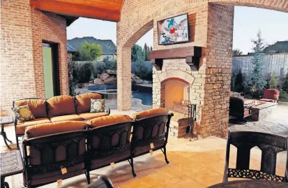  ??  ?? Outdoor living area with a fireplace and fire pit at a home designed by Brent Gibson at 14900 Laurin Lane.