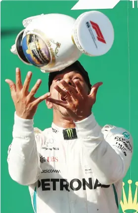  ?? Picture: AFP ?? SAFE HANDS. Lewis Hamilton does his signature trophy toss on the podium after winning the Hungarian Formula One Grand Prix at the Hungarorin­g yesterday.