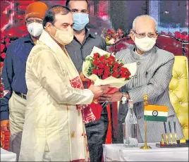  ??  ?? Assam governor Jagdish Mukhi greets the new chief minister of Assam, Himanta Biswa Sarma, during his swearing-in ceremony in Guwahati on Monday.