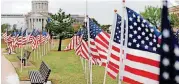  ?? [PHOTO BY JIM BECKEL, THE OKLAHOMAN] ?? Hundreds of U. S. flags are on display Wednesday along Lincoln Boulevard, south of the state Capitol in Oklahoma City. Each flag represents a child killed as a result of child abuse. The annual flag display is organized by Parent Promise.