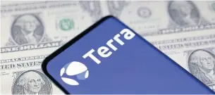  ?? ?? A smartphone shows the Terra logo against a backdrop of US dollar bills.