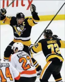  ?? THE ASSOCIATED PRESS FILE ?? Penguins captain Sidney Crosby raises his arms in celebratio­n with Patric Hornqvist, right, after scoring the game-winning goal in overtime during a meeting with the Flyers last Nov. 27 at PPG Paints Arena in Pittsburgh. The teams will collide there...