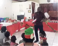  ??  ?? Pastor Charles Francis handing out loot bags to the children.