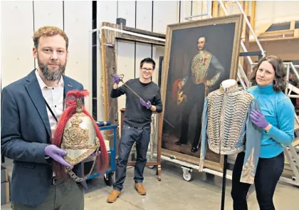  ??  ?? The museum’s Chris Cooper, Dr Peter Johnston (centre) and Eloise Maxwell with Lt Grant-Malcolmson’s ceremonial dress; his VC, far left and pistols, below