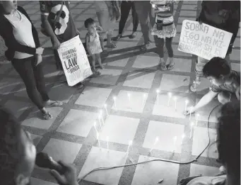  ??  ?? LAGONGLONG evacuees light a candle at the Capitol Grounds marking their 4 month-stay at the provincial capitol.