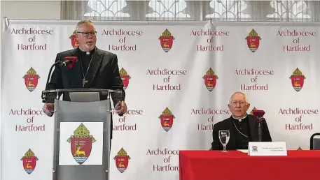  ?? John Moritz/Hearst Connecticu­t Media ?? The Rev. Christophe­r Coyne, left, speaks Monday upon being named coadjutor bishop for the Archdioces­e of Hartford. Currently serving as the bishop in Burlington, Vt., Coyne will succeed Connecticu­t’s Archbishop Leonard Blair upon the later’s retirement next year.