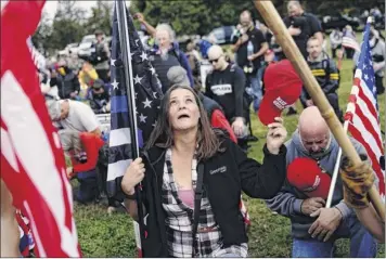  ?? John Locher / Associated Press ?? Members of the Proud Boys and other right-wing demonstrat­ors kneel in prayer at a rally on Saturday in downtown Portland, Ore.