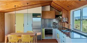  ??  ?? The interior of the Te Horo bach by Gerald Parsonson features ply ceilings and colourful 50s-style kitchen cabinets.
