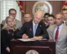  ?? ASSOCIATED PRESS ?? Florida Gov. Rick Scott signs the Marjory Stoneman Douglas Public Safety Act in the governor’s office at the Florida State Capitol in Tallahasse­e, Fla., on Friday. Scott is flanked by the victims’ parents Jennifer Montalto, left, Ryan Petty, second...