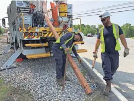  ?? BRANDON HOLVECK/DELAWARE NEWS JOURNAL ?? Delmarva Power workers construct a crossbar on-site. A worker will install it at the top of a pole using a bucket truck.