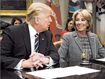  ?? EVAN VUCCI/AP 2017 ?? President Trump, seen with Education Secretary Betsy DeVos, has pushed hard to have schools reopen in the pandemic.
