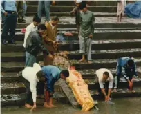  ??  ?? Pogrebci v Nepalu nosilo s truplom najprej položijo k vodi, vanjo namočijo njegove noge, ga polivajo in prižigajo paličice.