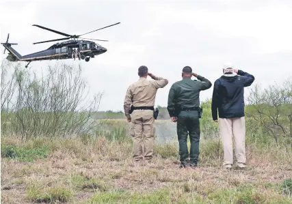  ??  ?? El presidente Donald Trump (der.), junto con otros dos oficiales saluda a un helicópter­o y agentes de la Patrulla Fronteriza que sobrevuela la zona de Río Grande, Texas, en la frontera entre México y Estados Unidos, el pasado 10 de enero.