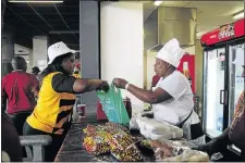  ?? PHOTO: THULANI MBELE ?? YUMMY: Emily Sekonyela sells food to a Kaizer Chiefs fan at R50 a serving at FNB stadium