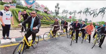  ?? PIC BY RASUL AZLI SAMAD ?? Chief Minister Datuk Seri Idris Haron trying out an OFO Eco Green bicycle at the launch of the ‘Basikal OFO Melaka Eco Green’ programme at Dataran Seri Negeri in Melaka yesterday.